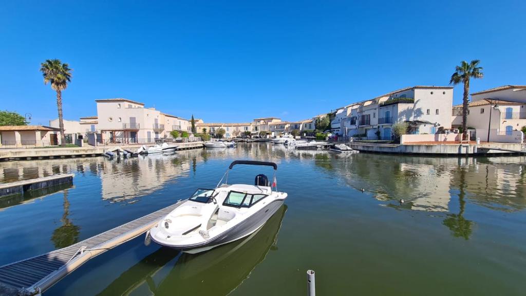 MARINA DEL SOL Aigues Mortes في إج مورت: يتم رسو قارب في مرسى في قناة مائية