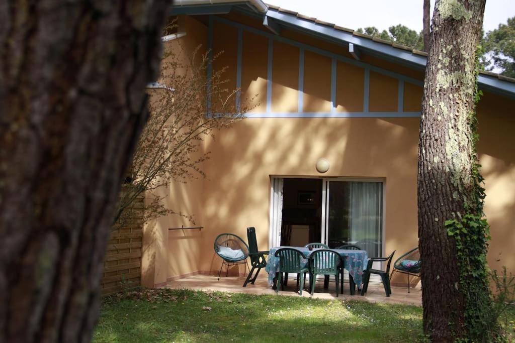 un patio con sedie e tavolo di fronte a una casa di appartement soustons plage a Soustons