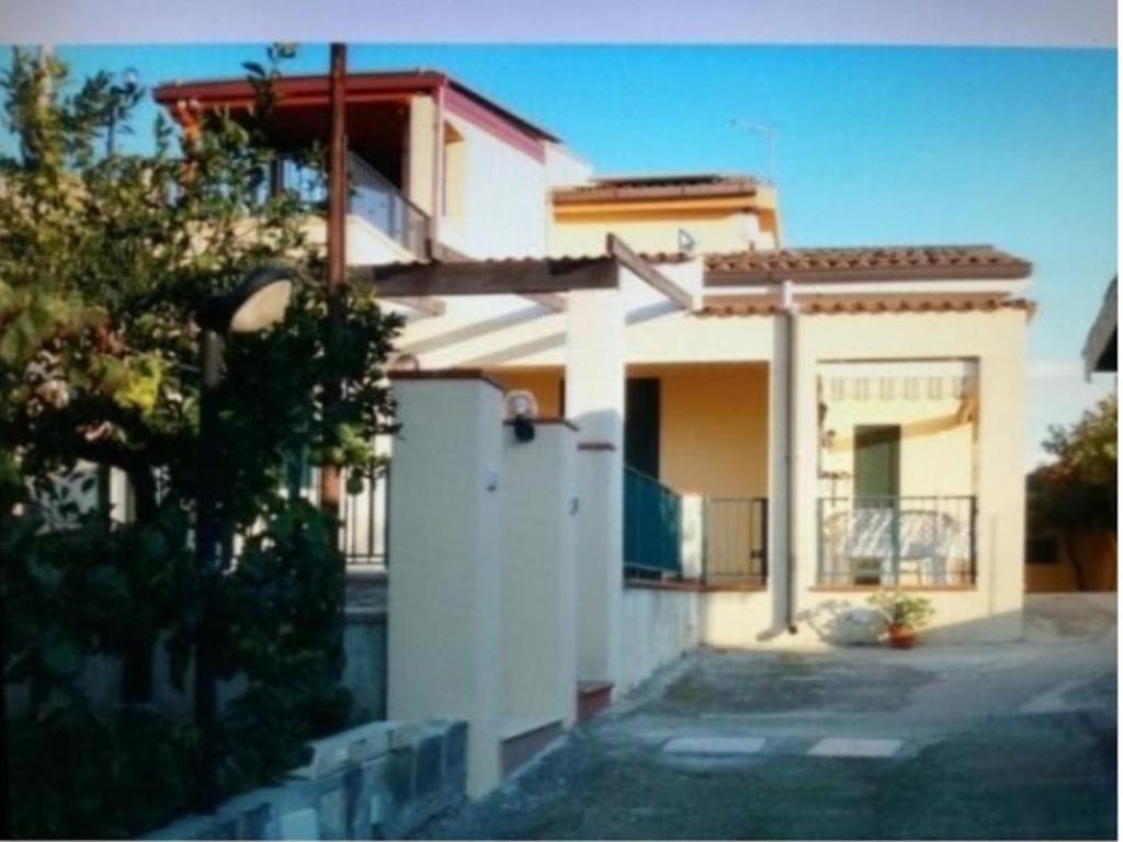 a white house with a fence in front of it at VILLA ROSY LIDO di NOTO in Noto Marina