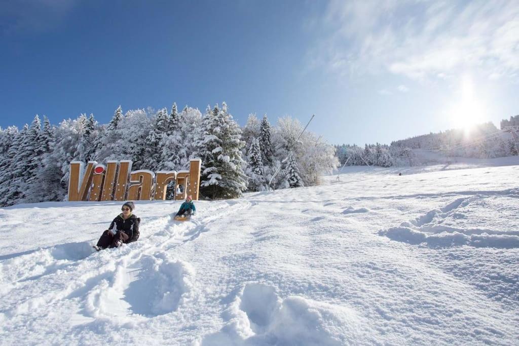 une personne assise dans la neige à côté d'un panneau dans l'établissement Location saisonnière 4 couchages, à Villard-de-Lans