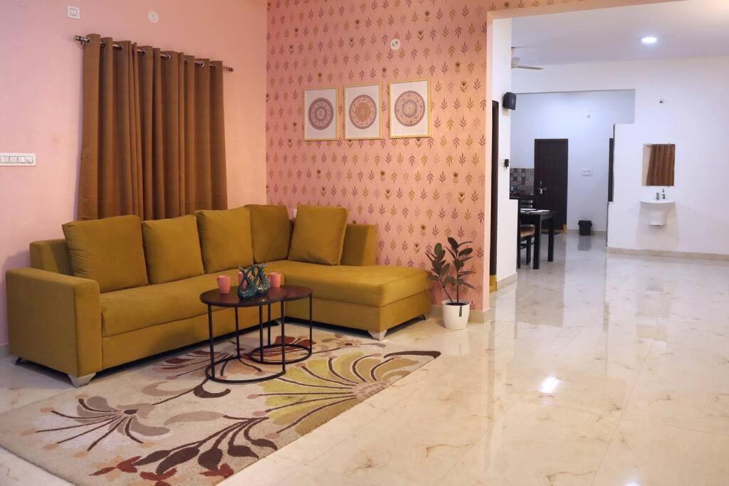 ハイデラバードにあるVeetil -3BHK AC, Kukatpally, Hyderabadの黄色いソファとテーブルのあるリビングルーム