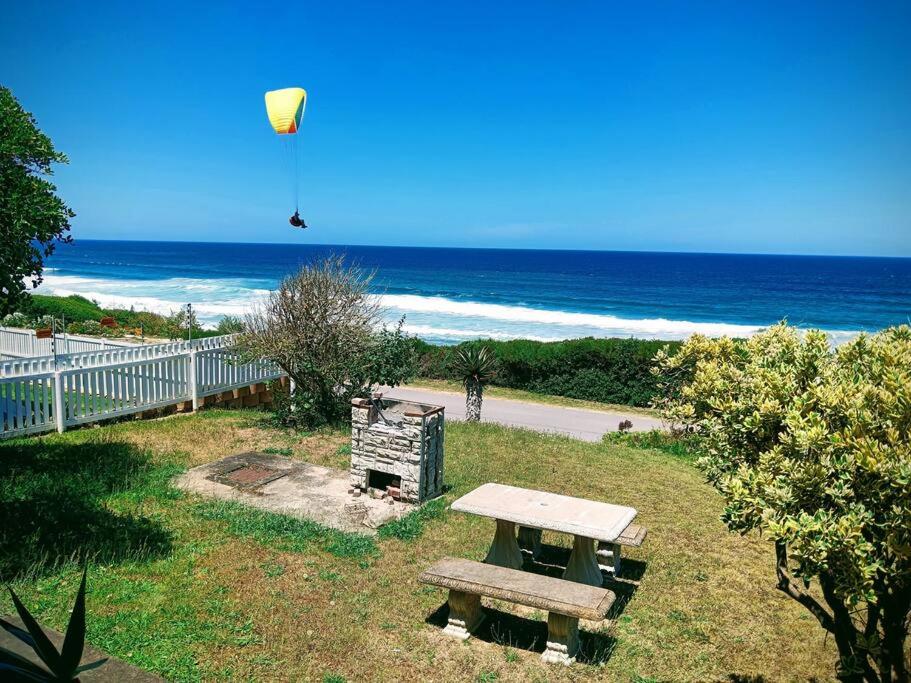a picnic table and a kite flying over the beach at Family beachfront cottage in Tergniet