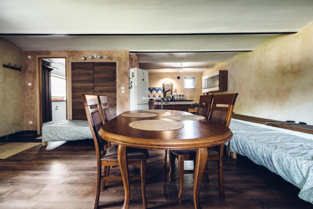 a dining room with a table and chairs and a bed at Kogutowo Agroturystyka MPR in Wietrzychowice