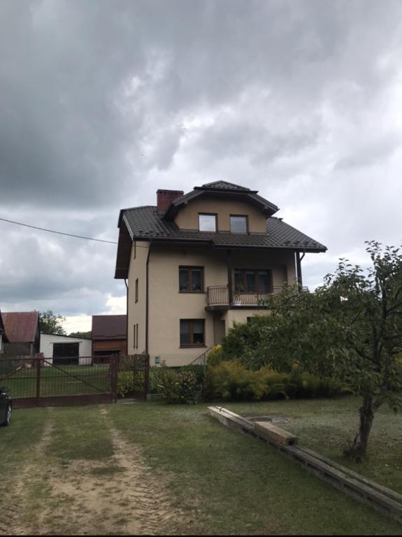 a house with a black roof on top of a yard at Leśne Zacisze in Augustów
