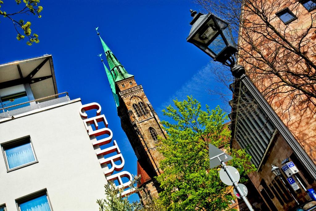 un alto campanile con un campanile su un edificio di Hotel Central a Norimberga