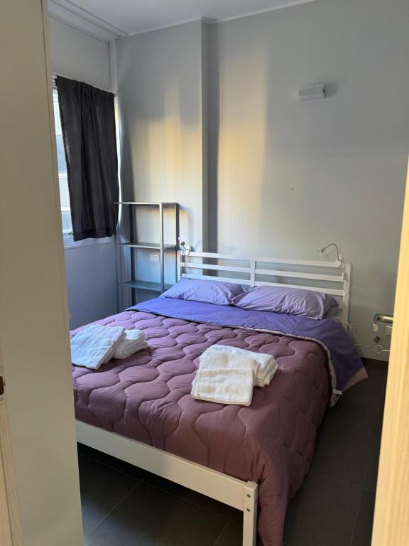 een slaapkamer met een bed met paarse lakens en een spiegel bij Al 304 a San Giovanni in Rome