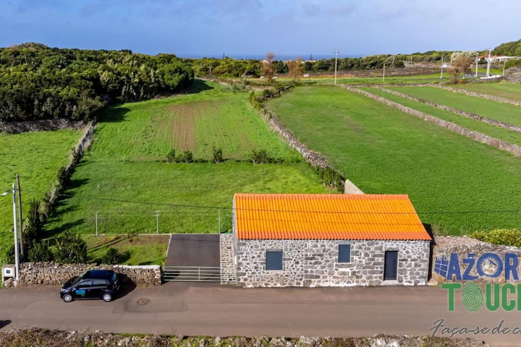a car parked in front of a building with an orange roof at Casa do Jardim in Santa Cruz da Graciosa