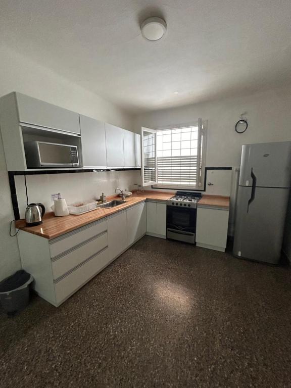 a kitchen with white cabinets and a refrigerator at La Casita de Salta 421 in Concordia