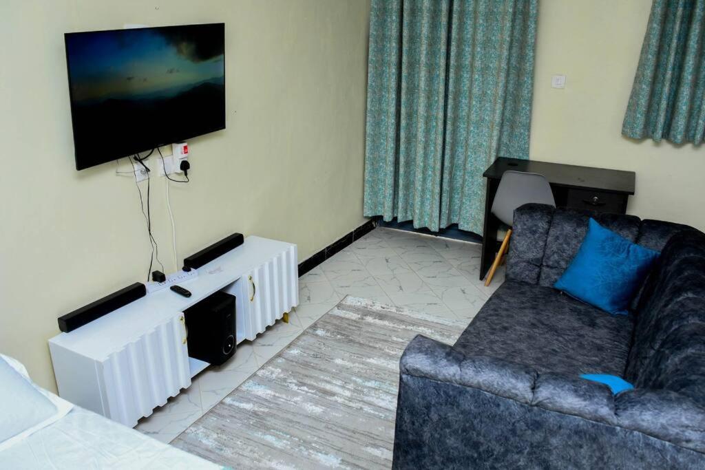 a living room with a couch and a flat screen tv at Tala Cosy Homes in Tawa