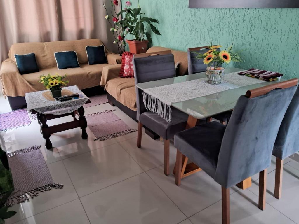 uma sala de estar com uma mesa, cadeiras e um sofá em Apartamento Praia da Enseada no Guarujá