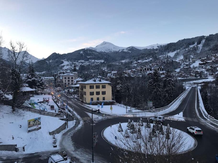 une ville enneigée avec une route et une montagne dans l'établissement Appart cosy et lumineux au cœur de Saint Gervais, à Saint-Gervais-les-Bains