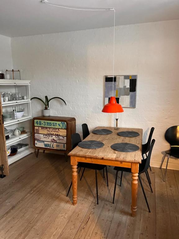 a table with chairs and a lamp in a room at City House in Odense
