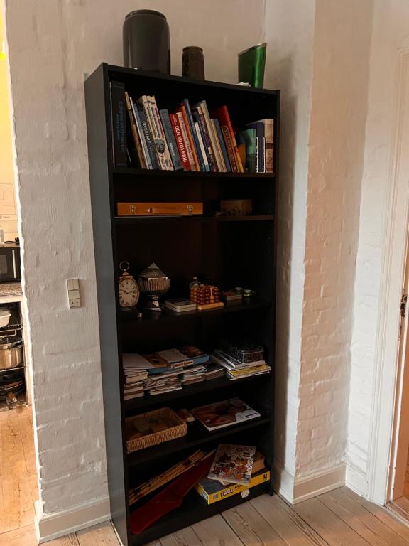 a black book shelf filled with books at City House in Odense