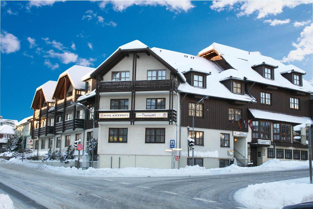a large building with snow on top of it at Hotel Achtermann in Braunlage