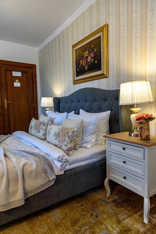 德瓦Vila SaraDa Boutique的卧室里有一张床和一张带灯的桌子