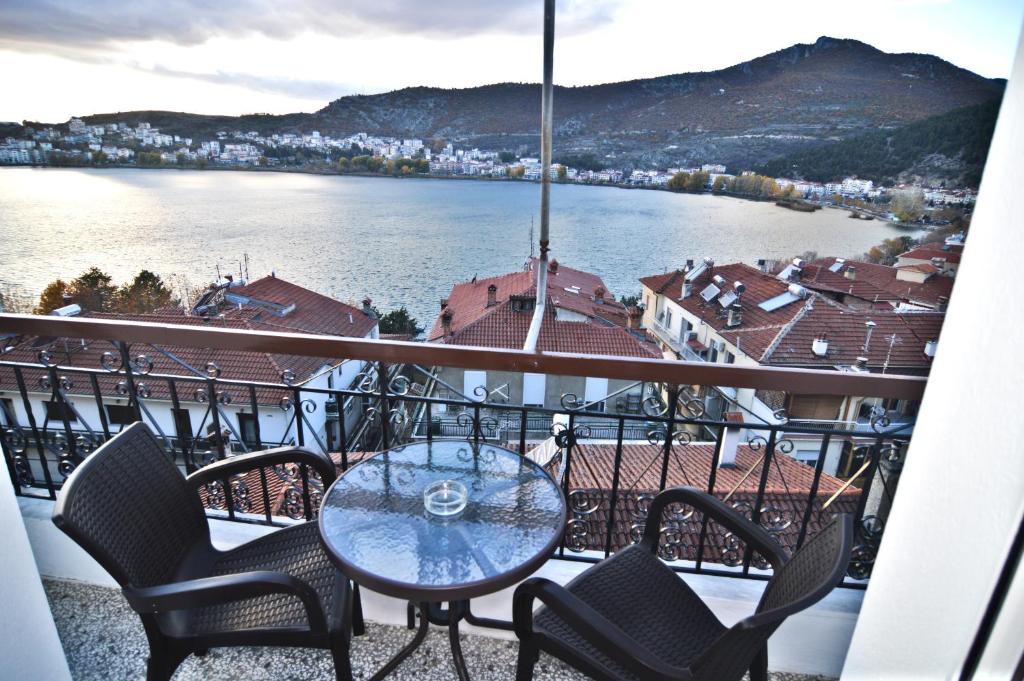 a table and chairs on a balcony with a view of the water at Konstantina's Sky View in Kastoria