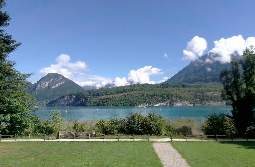 une vue d'un lac avec des montagnes en arrière-plan dans l'établissement Chalet au bord du lac, à Saint-Jorioz