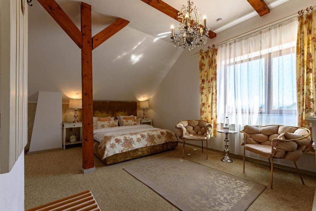a bedroom with a large bed and a chandelier at Vila SaraDa Boutique in Deva