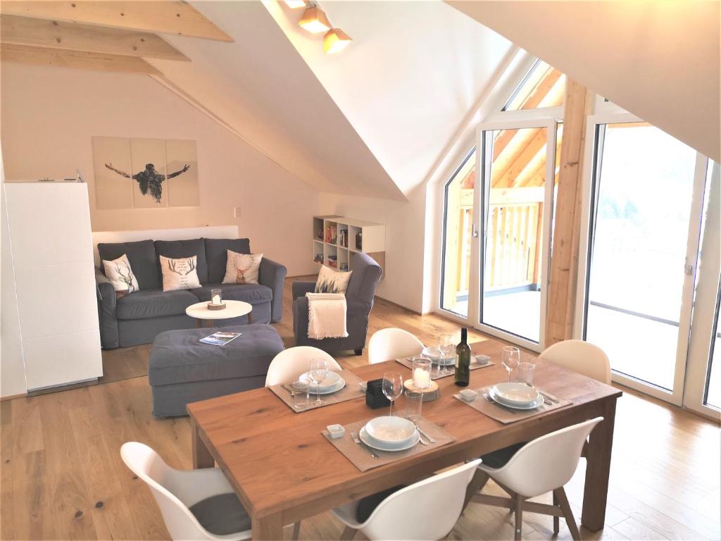 Tauplitz Panorama Apartment, 75qm, Balkon und Sauna في توبليتز: غرفة معيشة بها طاولة وكراسي