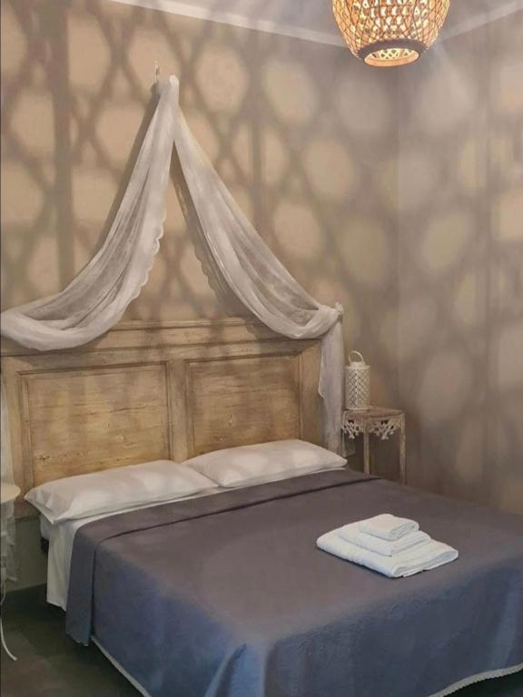 a bedroom with a canopy bed with towels on it at Dimora Storica Silver Room in Ruviano