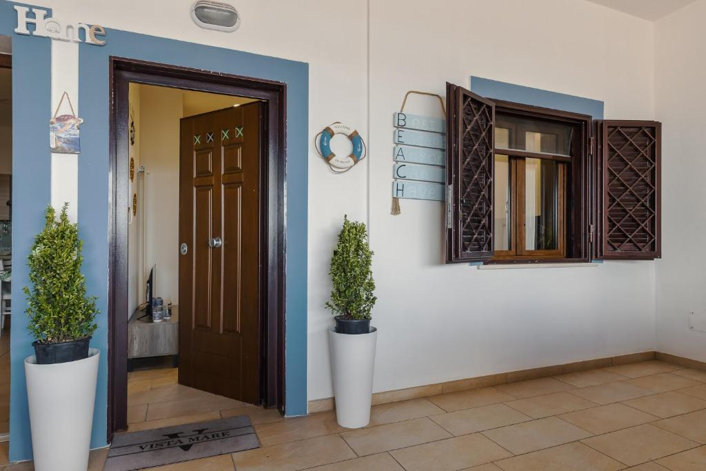 a hallway with a door and two potted plants at Vista mare AirPort in Fiumicino