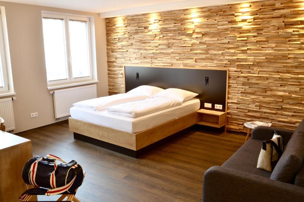 een slaapkamer met een bed en een bakstenen muur bij Hotel FIVE in Neurenberg