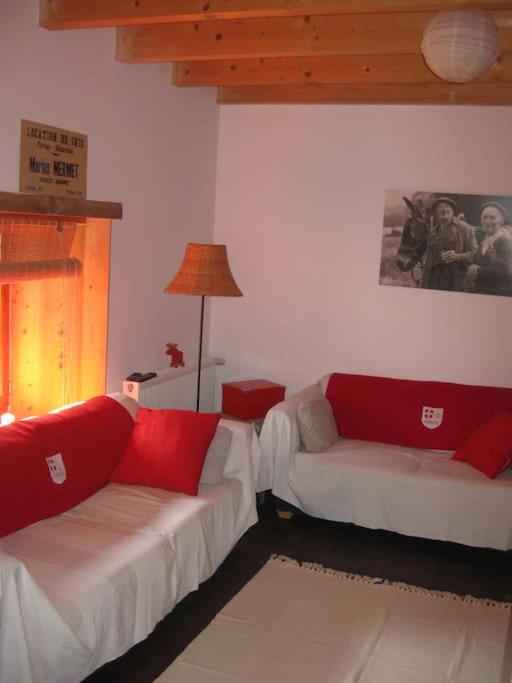 - un salon avec deux canapés blancs et des oreillers rouges dans l'établissement Joli appartement de village, à Boussy