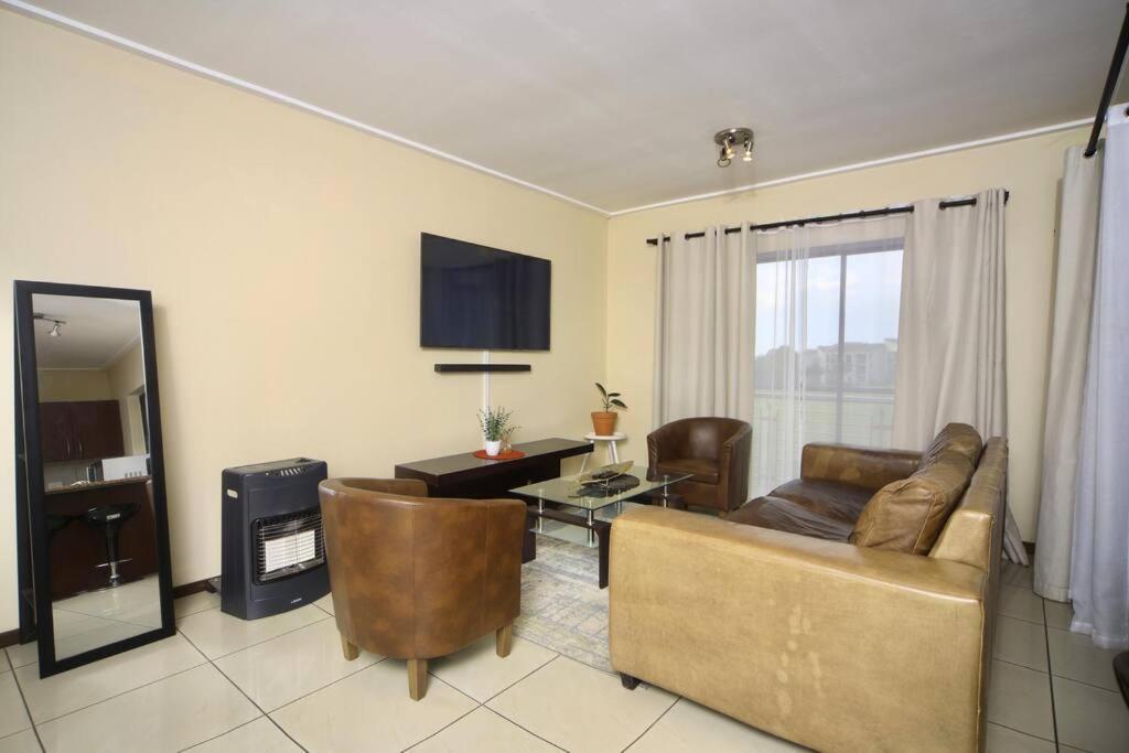 een woonkamer met een bank en een tafel bij Golfers Estates in Roodepoort