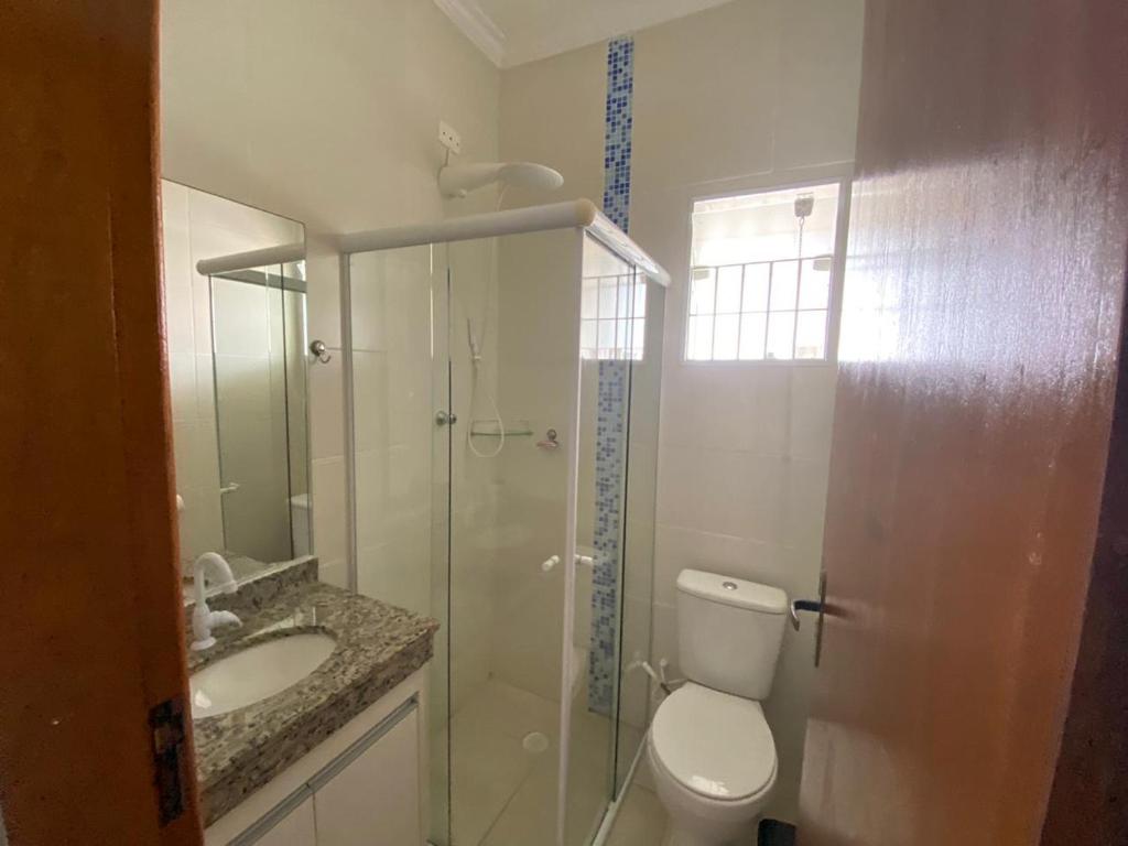 Un baño con ducha, inodoro y lavabo. en Casa Recanto em Itanhaém, en Itanhaém