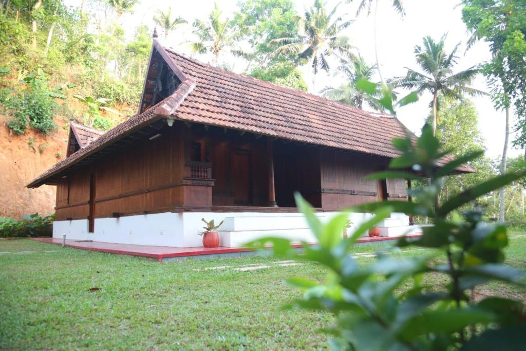 a small house with a red rug in front of it at Poovar Heritage Homes in Pūvār
