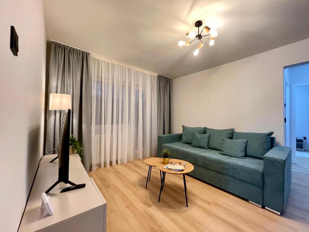 アルバ・ユリアにあるSunset Apartmentsの青いソファとテーブルのあるリビングルーム