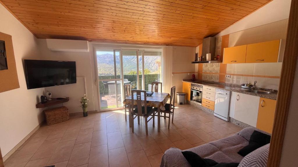 a kitchen with a table and a dining room at CA LIDIA-Apartamentos Turísticos EL CAMPANAR 1 in Benimantell