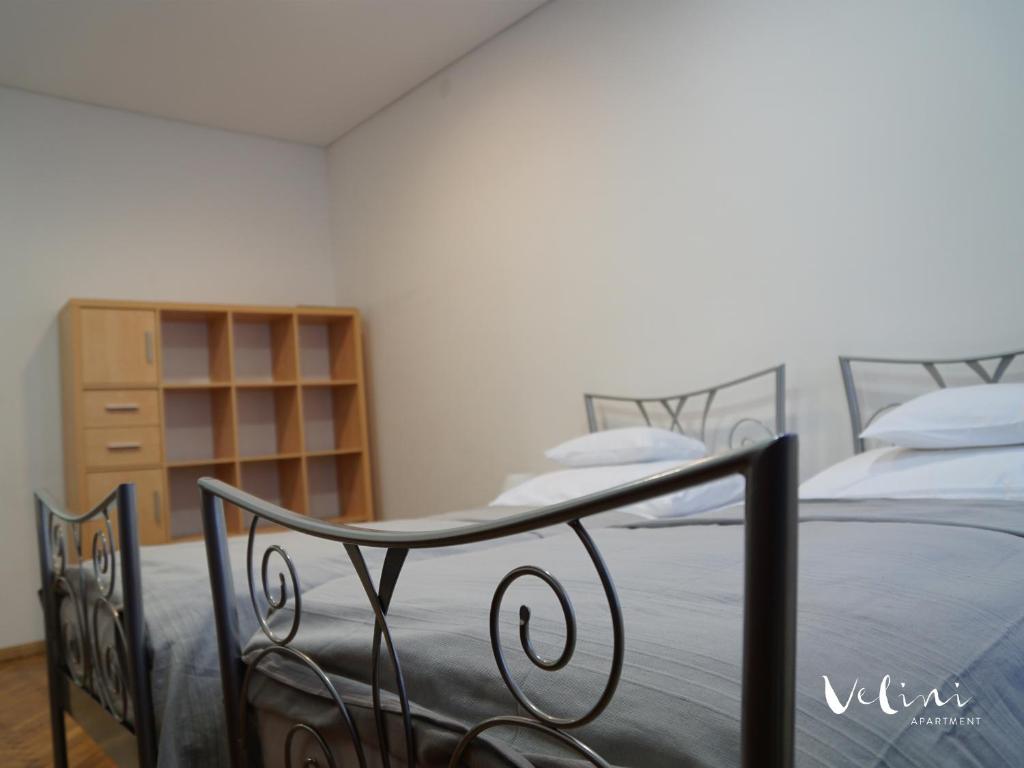 a bedroom with two beds and a book shelf at Apartment Velini in Zagreb
