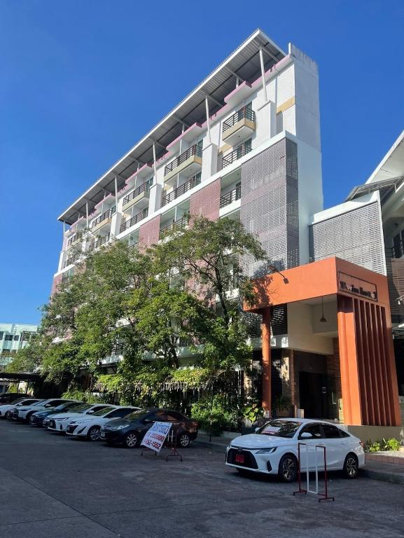 a parking lot with cars parked in front of a building at Twin Hotel in Phuket