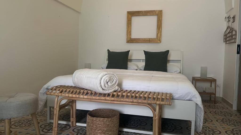 a bedroom with a bed and a bench with a mirror at Vicolo 4 Locazione Turistica in Monopoli