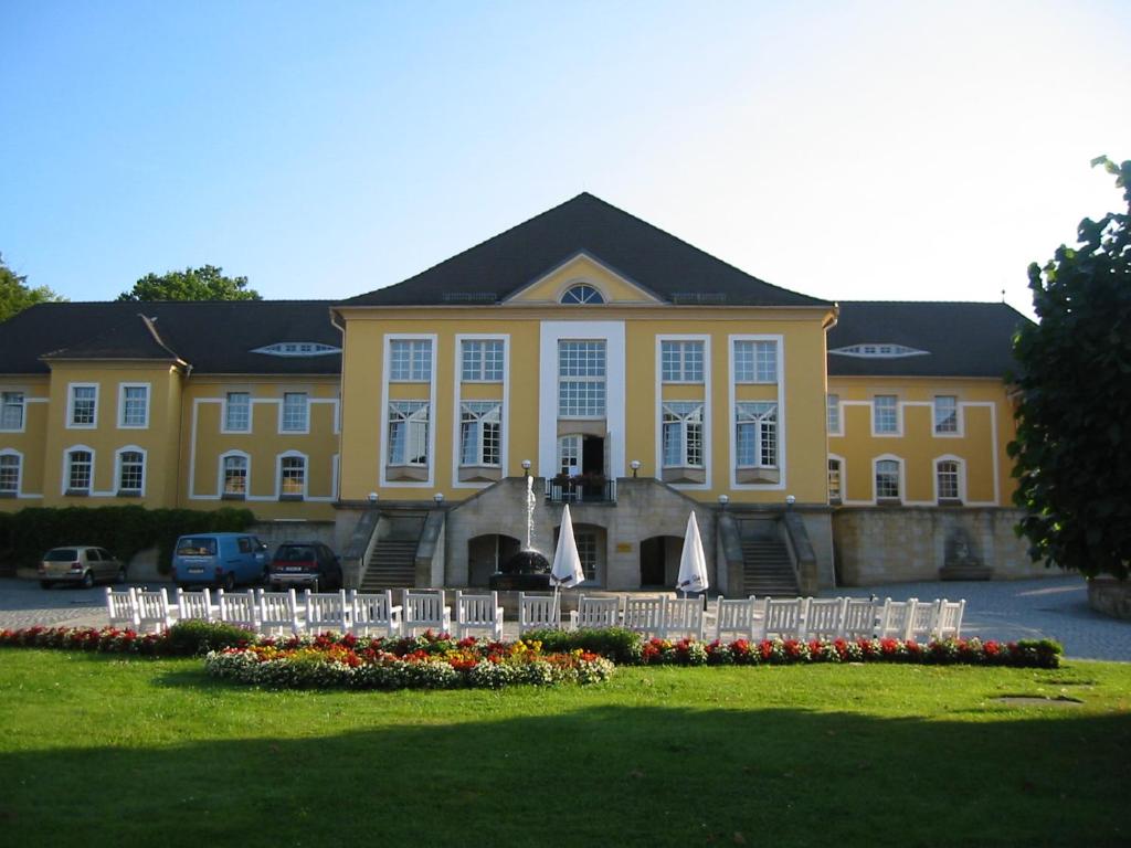 a large yellow building with tables and chairs in front of it at Bildungsgut Schmochtitz in Schmochtitz