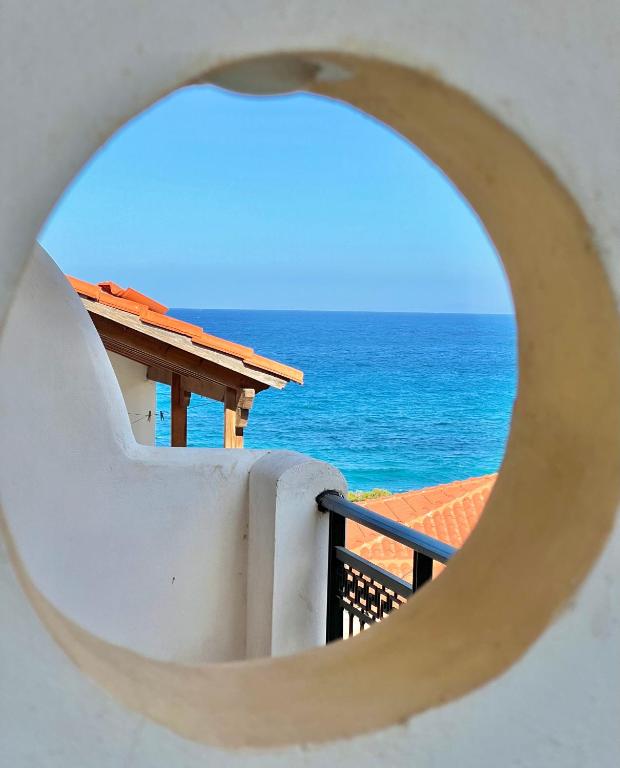 a view of the ocean through a hole in a wall at Marinos Studios and Apartments in Gialiskari
