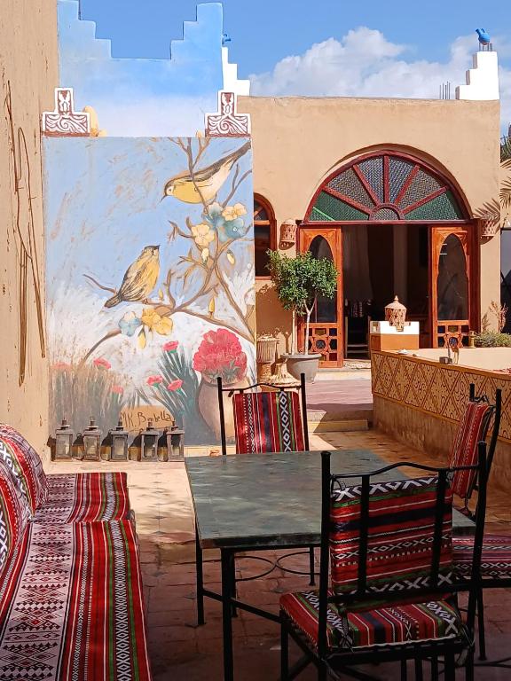 un tavolo e sedie di fronte a un quadro di Dar M'hamid a M'Hamid