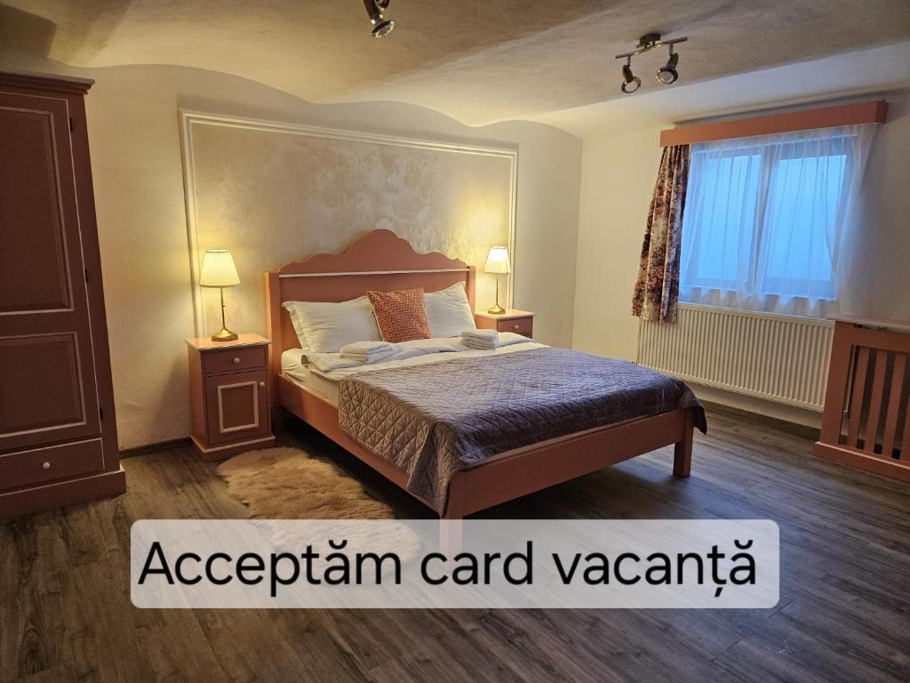 a bedroom with a bed and two tables and a window at Casa Raduly - Apartament Demisol in Sibiu