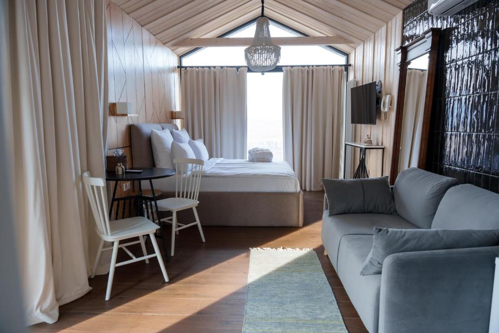 una sala de estar con un sofá y una cama en Shakaryan Rancho&Restaurant, en Tumanyan