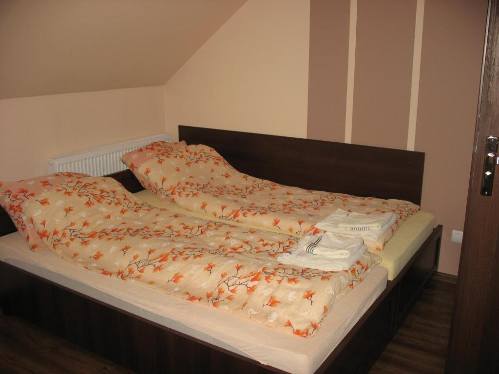 ein Bett mit einer Bettdecke und Kissen darauf in der Unterkunft Willa Viola in Busko-Zdrój