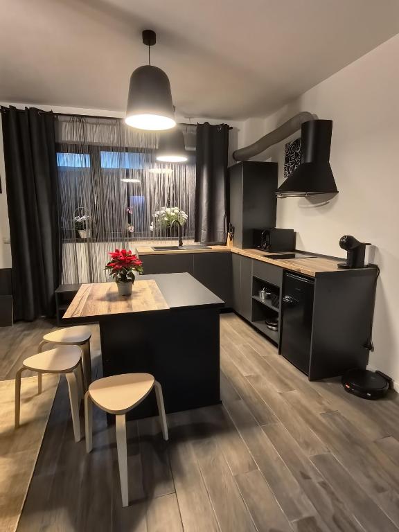 a kitchen with black cabinets and a table and chairs at Best City Green in Craiova