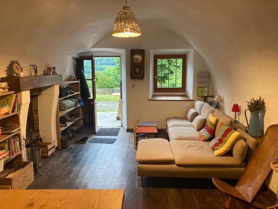 un salon avec un canapé et une cheminée dans l'établissement Maison de village avec jardin, à Saint Firmin