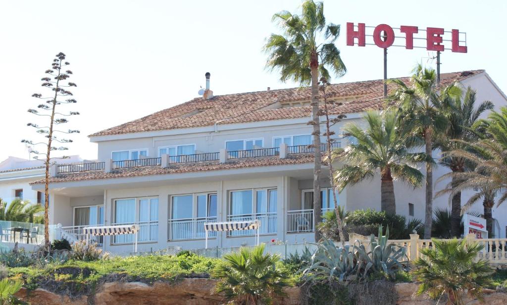 un hotel con palme di fronte di Hotel La Riviera a Albir