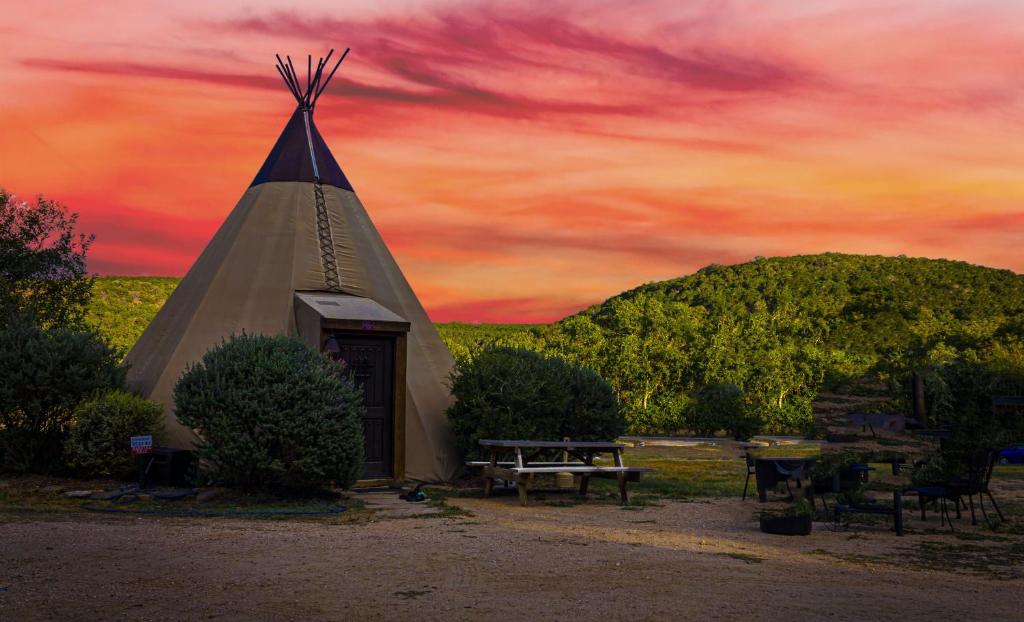 a pyramid building with a picnic table and a sunset at Rising Moon - Tipi 8 in Fourth Crossing