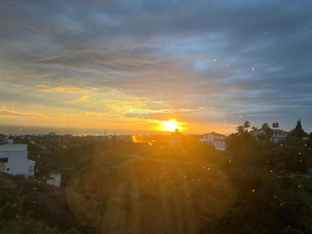 a sunset over a city with the sun setting at Marbella Boutique Art suites in Marbella
