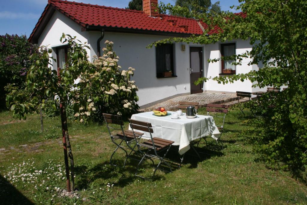 a table and chairs in front of a white house at Ferienhaus "Kleiner Schoner" in Rerik