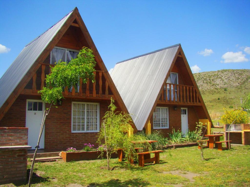 una casa con techo de metal y patio en Cabañas Mirador del Cerro en Sierra de la Ventana
