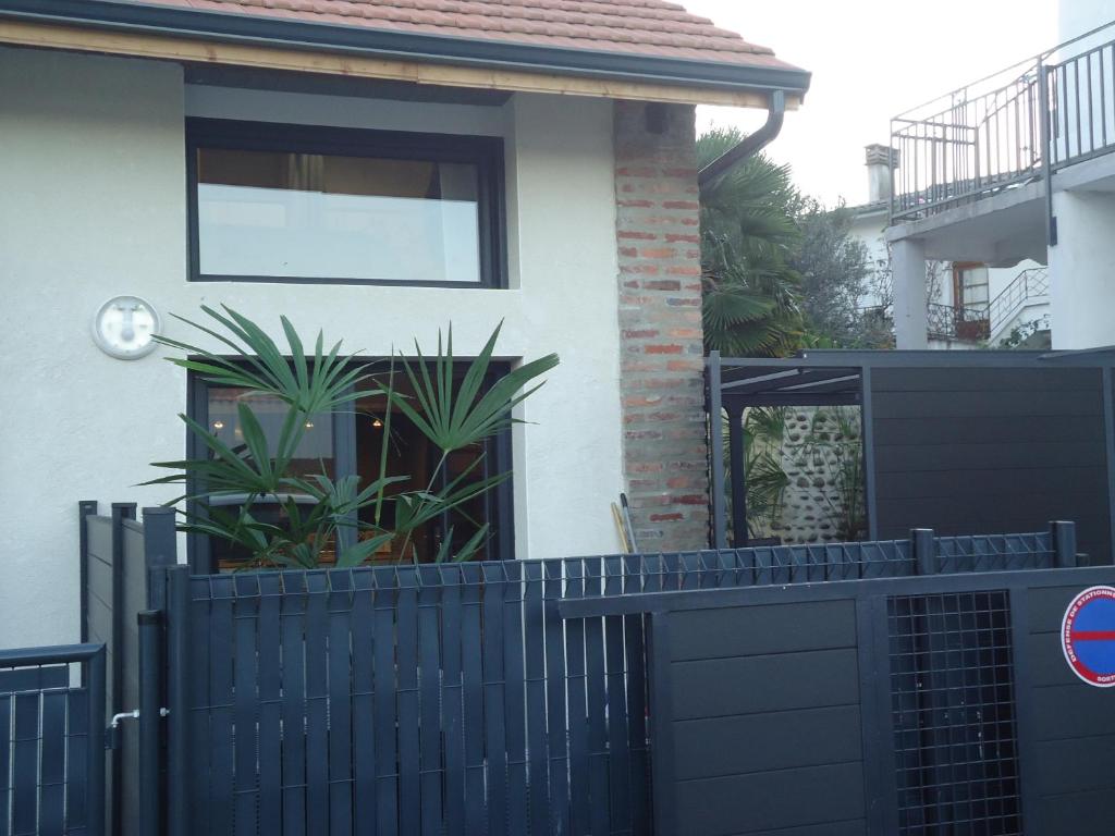 a black fence in front of a house at Les spas de la Chartreuse in Tarbes
