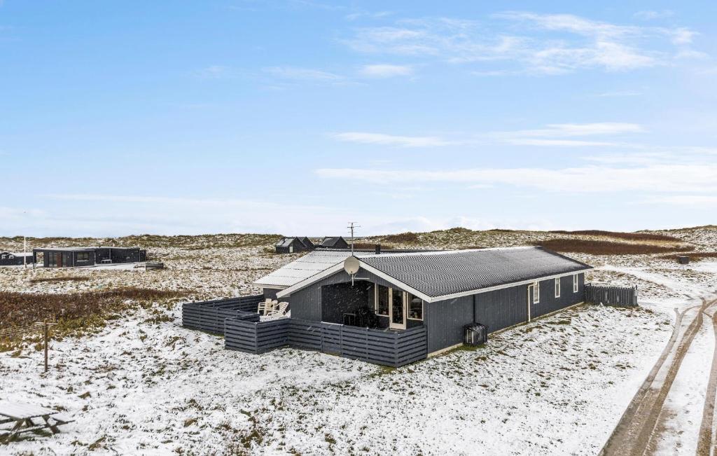 a small black house in the middle of a desert at Gorgeous Home In Thisted With Sauna in Klitmøller